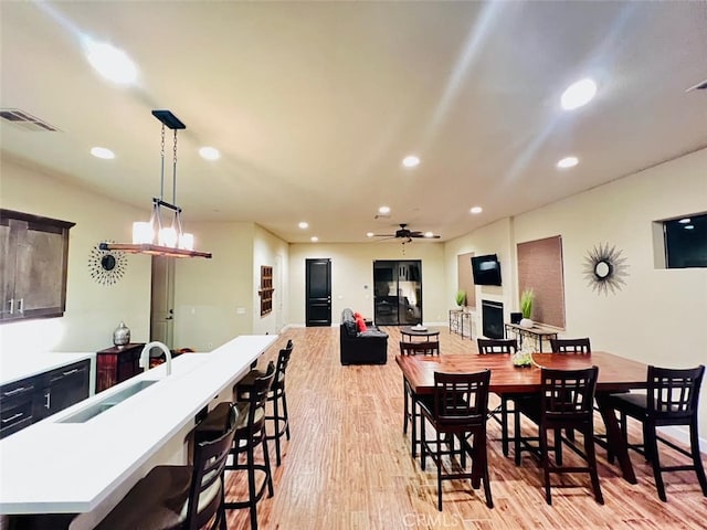 dining area featuring light hardwood / wood-style floors, sink, and ceiling fan