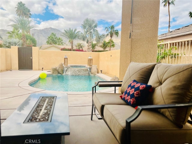 view of swimming pool with a mountain view, an in ground hot tub, a patio, pool water feature, and an outdoor living space