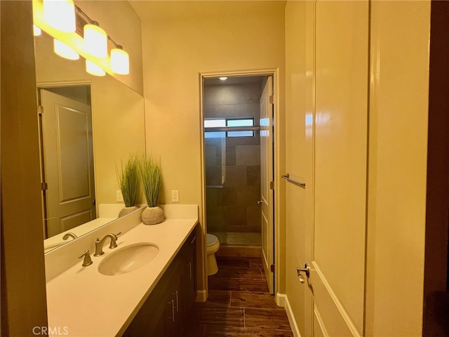 bathroom with vanity, a shower with shower door, toilet, and hardwood / wood-style flooring