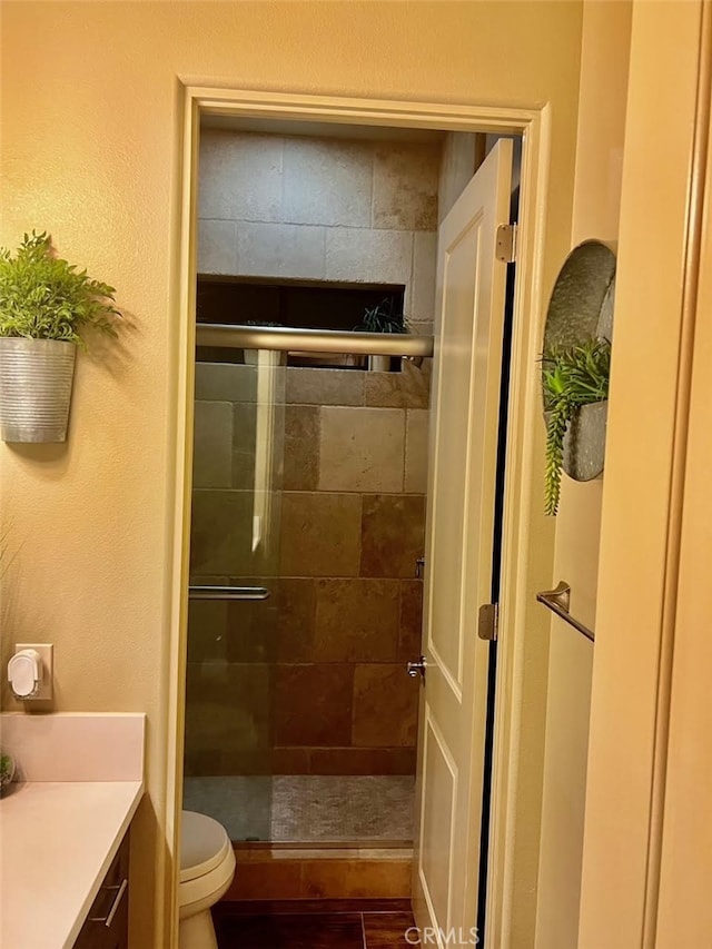 bathroom featuring walk in shower, vanity, toilet, and tile patterned floors