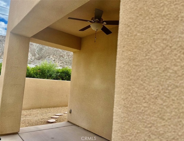 view of patio with ceiling fan and a mountain view