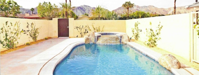 view of swimming pool with a patio and a mountain view