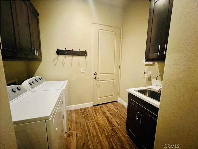 clothes washing area featuring cabinets, light hardwood / wood-style floors, sink, and independent washer and dryer