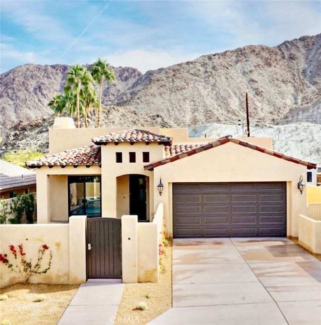 mediterranean / spanish-style house with a mountain view and a garage