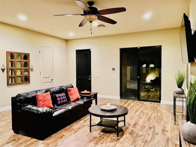 living room featuring light hardwood / wood-style flooring and ceiling fan