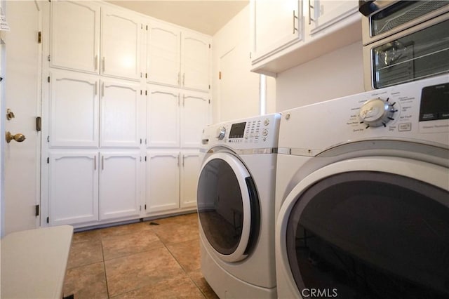 washroom featuring light tile patterned flooring, cabinet space, and washer and dryer