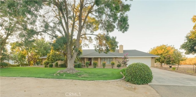 ranch-style house featuring a front lawn, a garage, driveway, and a chimney