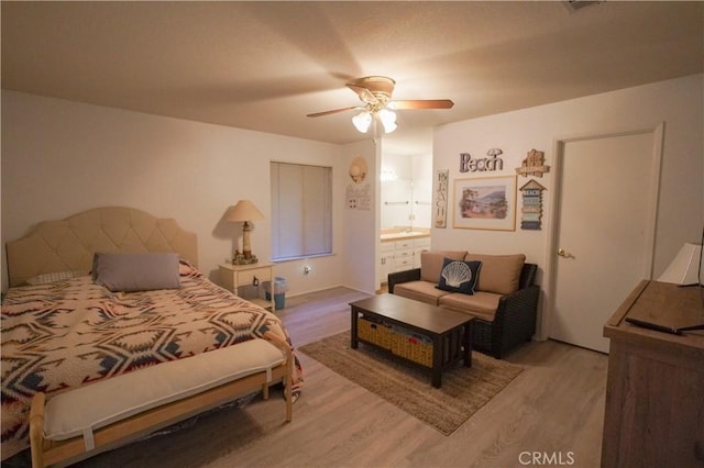 bedroom featuring wood finished floors, ensuite bathroom, and ceiling fan