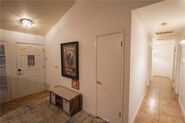 foyer entrance featuring light tile patterned floors, baseboards, and visible vents