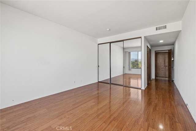 unfurnished bedroom featuring hardwood / wood-style flooring and a closet