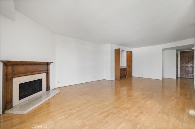 unfurnished living room with light wood-type flooring and a fireplace