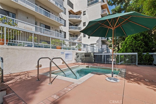 view of swimming pool with a hot tub