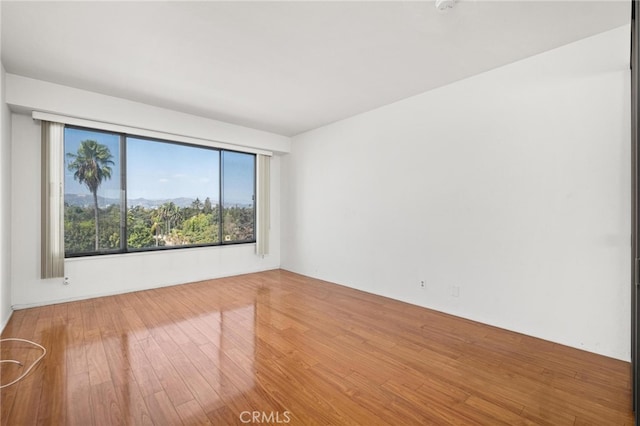 unfurnished room with hardwood / wood-style flooring