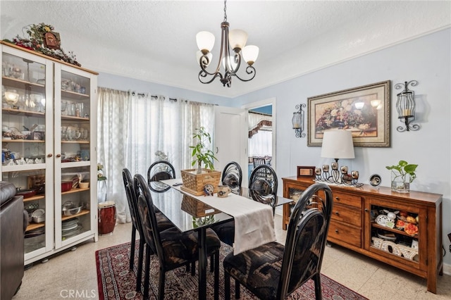 dining space with an inviting chandelier, a textured ceiling, and a healthy amount of sunlight