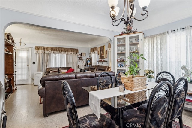 dining space with a notable chandelier and a textured ceiling