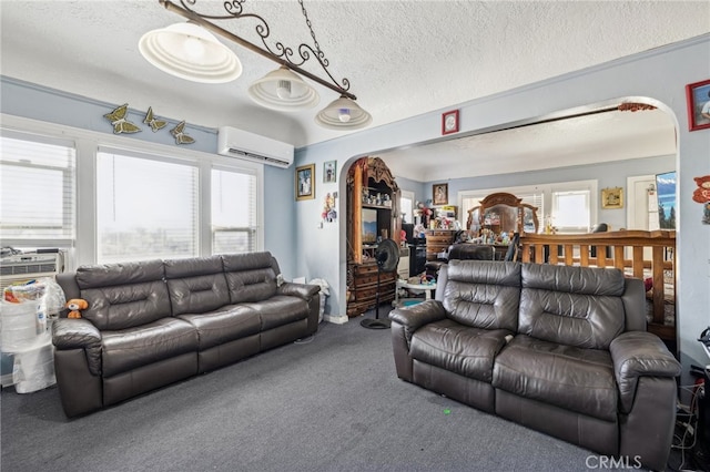 living room featuring a textured ceiling, carpet flooring, and an AC wall unit