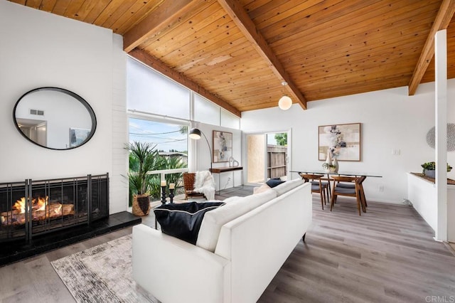 living room featuring beamed ceiling, wood-type flooring, wooden ceiling, and high vaulted ceiling