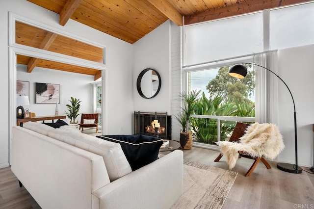 living room with lofted ceiling with beams, hardwood / wood-style flooring, wooden ceiling, and a fireplace