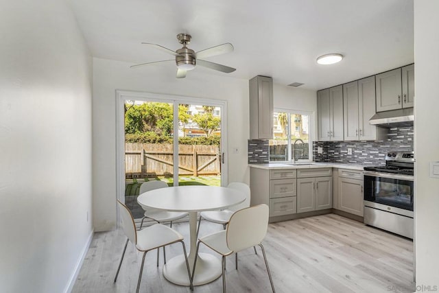 kitchen with gray cabinetry, light hardwood / wood-style floors, electric range, and ceiling fan