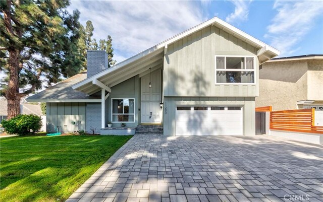 view of front of home with central AC unit, a front yard, and a garage