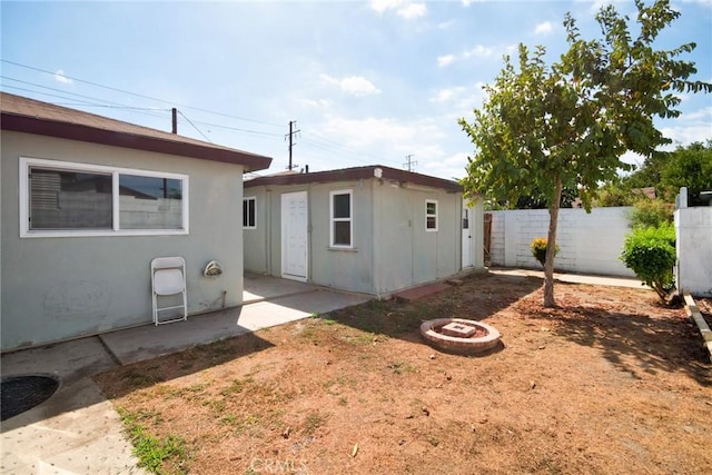 rear view of property with an outdoor fire pit and a patio