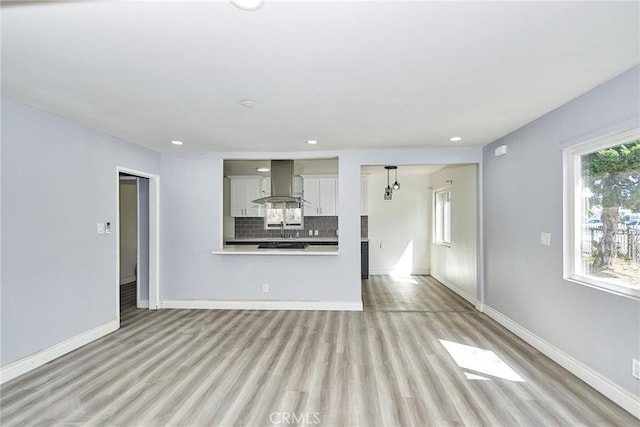 unfurnished living room with light hardwood / wood-style flooring and sink