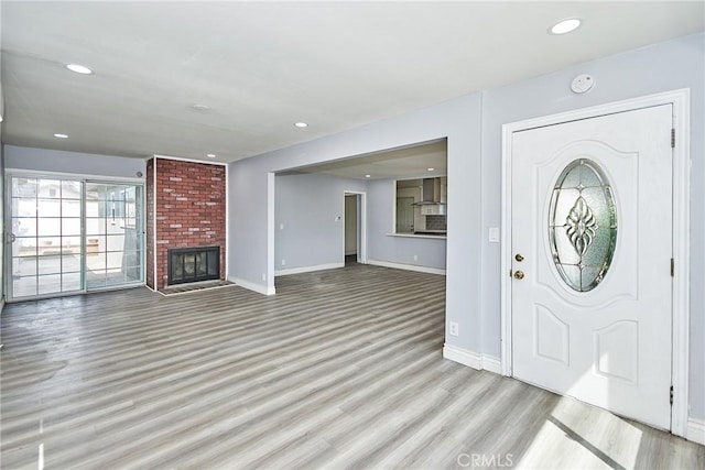 entrance foyer featuring light hardwood / wood-style floors and a fireplace