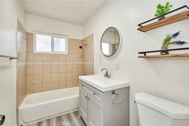 full bathroom with vanity, hardwood / wood-style flooring, toilet, and tiled shower / bath combo