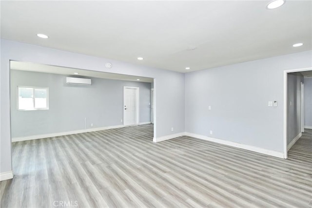 interior space with a wall mounted AC and light wood-type flooring