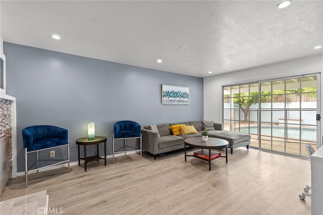 living room featuring a textured ceiling and light hardwood / wood-style floors