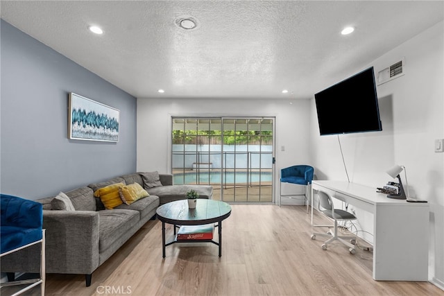 living room featuring a textured ceiling and light hardwood / wood-style floors