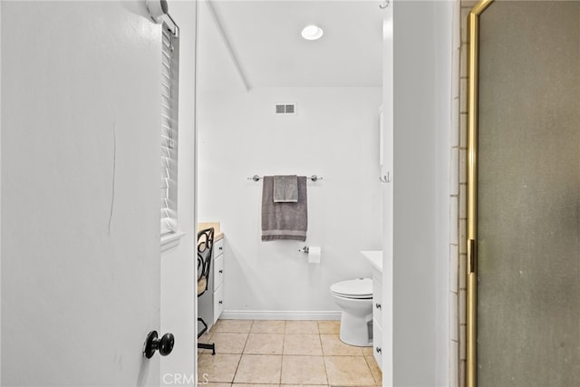 bathroom featuring tile patterned flooring, vanity, toilet, and walk in shower