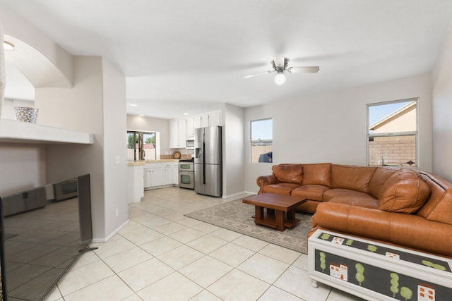 tiled living room featuring a healthy amount of sunlight and ceiling fan