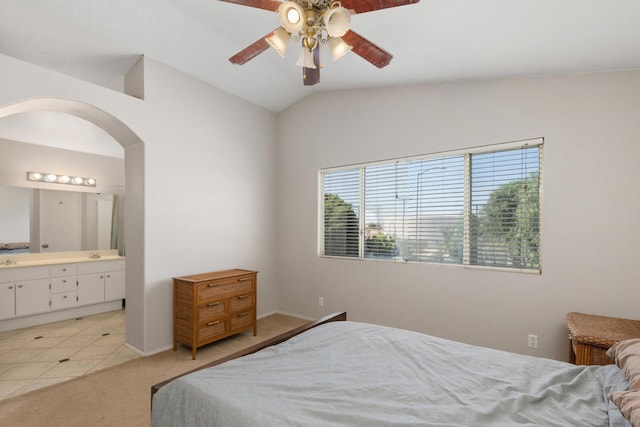 bedroom featuring light tile patterned floors, connected bathroom, vaulted ceiling, and ceiling fan