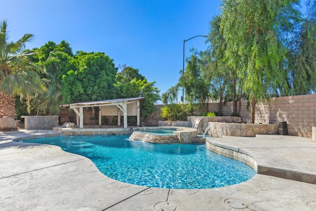 view of pool with pool water feature, an in ground hot tub, and a patio area