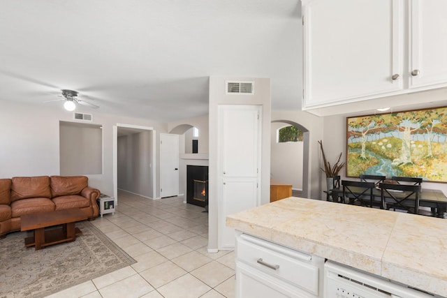 kitchen with light tile patterned floors, dishwasher, ceiling fan, and white cabinets