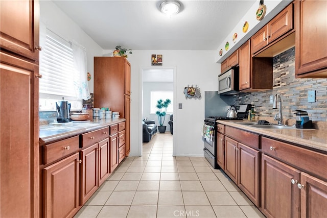 kitchen with a wealth of natural light, sink, tasteful backsplash, and black gas range