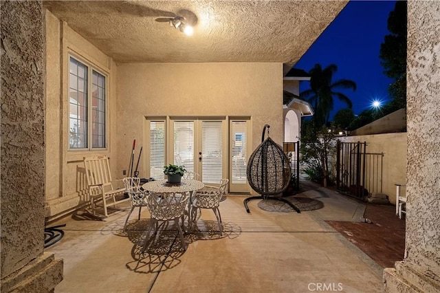 patio at night with fence and french doors