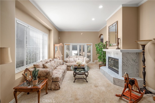 living room featuring a premium fireplace, crown molding, and carpet floors