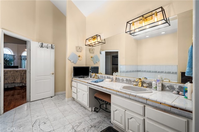 bathroom featuring vanity, hardwood / wood-style flooring, and high vaulted ceiling