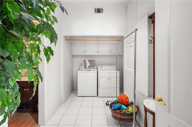 laundry room with laundry area, baseboards, light tile patterned floors, visible vents, and washing machine and dryer