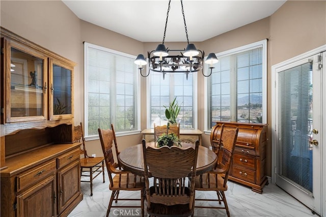 dining space featuring an inviting chandelier and marble finish floor