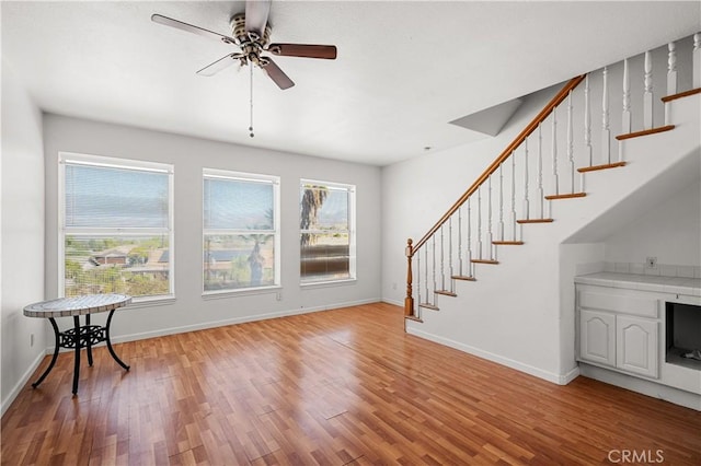interior space featuring plenty of natural light, a ceiling fan, light wood finished floors, and stairway
