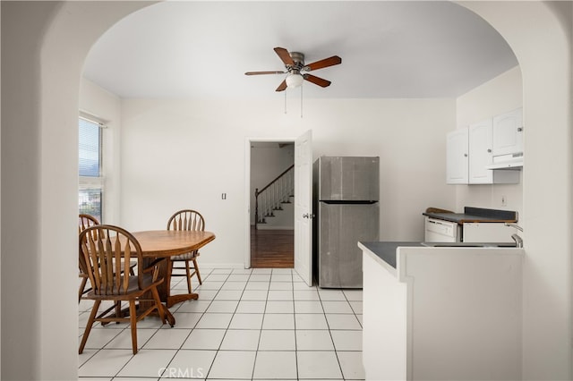 kitchen with white dishwasher, light tile patterned flooring, white cabinetry, stainless steel refrigerator, and ceiling fan