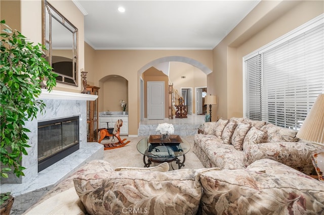 carpeted living room with crown molding and a fireplace