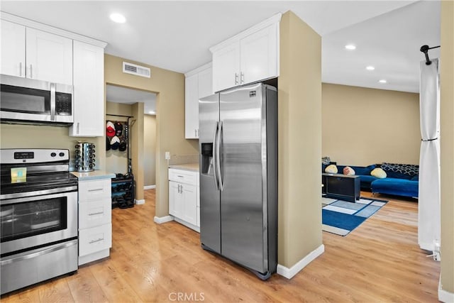 kitchen featuring white cabinetry, light hardwood / wood-style floors, and appliances with stainless steel finishes