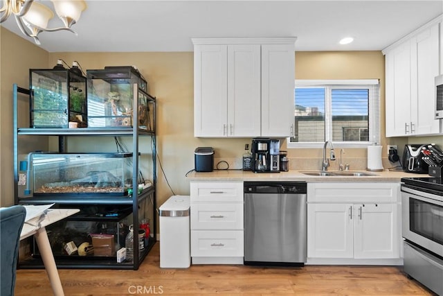 kitchen featuring sink, white cabinets, stainless steel appliances, and light hardwood / wood-style floors