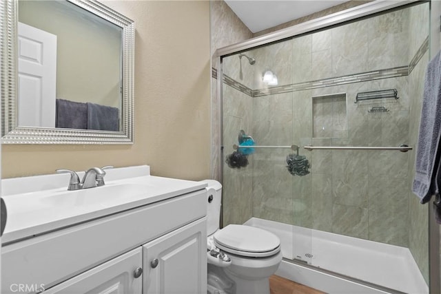 bathroom with vanity, toilet, and an enclosed shower