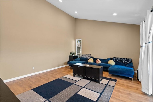 living room with light hardwood / wood-style floors and vaulted ceiling