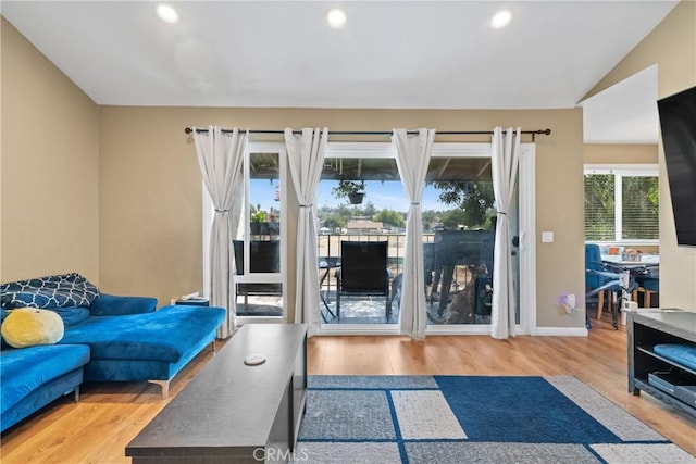 living room with light wood-type flooring and vaulted ceiling